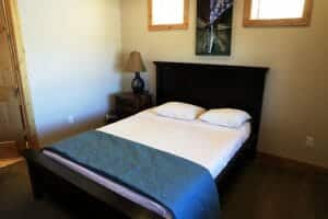 a neatly made full sized bed inside of a vacation home at Zion Ponderosa Ranch