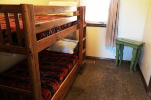 a neatly made bunk bed inside of a vacation home at Zion Ponderosa Ranch