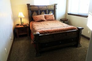 a neatly made double bed inside of a vacation home at Zion Ponderosa Ranch