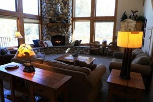 A cozy couch and a stone a large stone fireplace inside of a vacation home at Zion Ponderosa Ranch