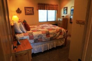 a neatly made full sized bed inside of a vacation home at Zion Ponderosa Ranch
