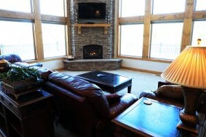 a comfortable couch and a stone fireplace inside of a vacation home at Zion Ponderosa Ranch