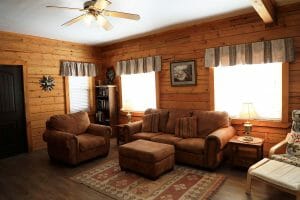 a cozy couch in a wood walled living room at a vacation home at Zion Ponderosa Ranch