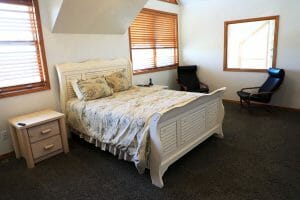 a double bed, 2 leather chairs, and a large mirror in a vacation home near Zion national park