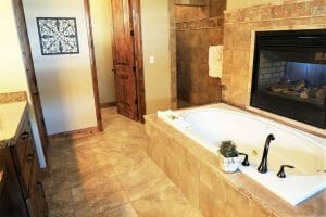 a lavishly bathroom with a jetted bathtub next to a fireplace in a vacation home near Zion national park