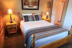 a full sized bed in a small bedroom in a cabin at zion ponderosa ranch