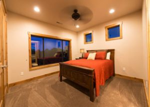 Bedroom 2 in unit 755 is neatly made with a newly vacuumed and clean floor with a scenic window view