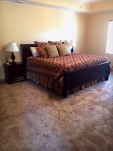 a bed is nicely made in a large bedroom in unit 756