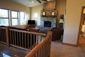 An upstairs living room with couches and a stone fireplace in a rental home in southern Utah