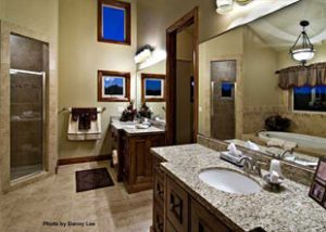 A nice and clean bathroom has his and her sinks and counters separated by a closet door