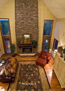 An overhead view of a lavish living room area in a rental home near Zion national Park with a large stone fireplace