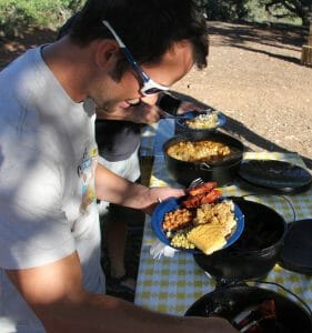 man eating food while camping