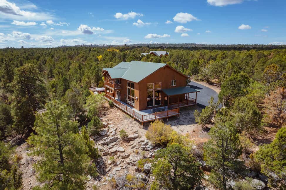 Large house with green roof in a forest used for vacation rentals in Southern Utah near Zion National Park