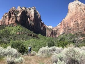 a woman practices social distancing in zion national park