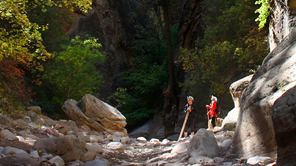 2 People on a guided hike through a canyon, one of the most popular zion national park activities