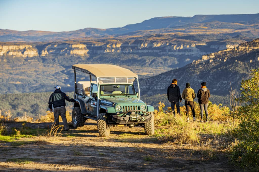 a jeep and people overlooking cliffs